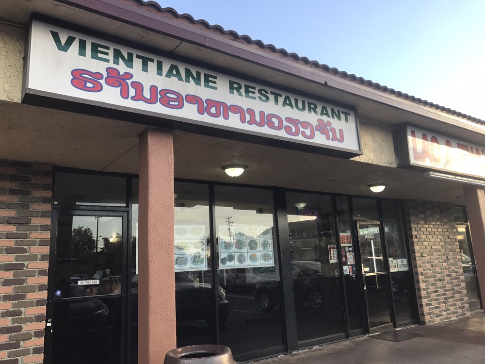Vientiane Restaurant sign in English and Lao above the storefront