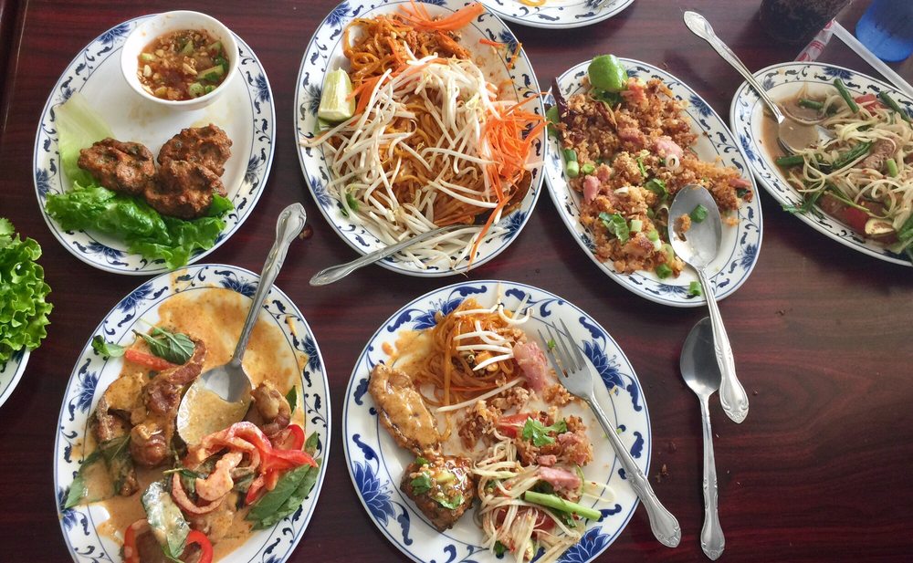 A table spread of salads, curries and noodle dishes